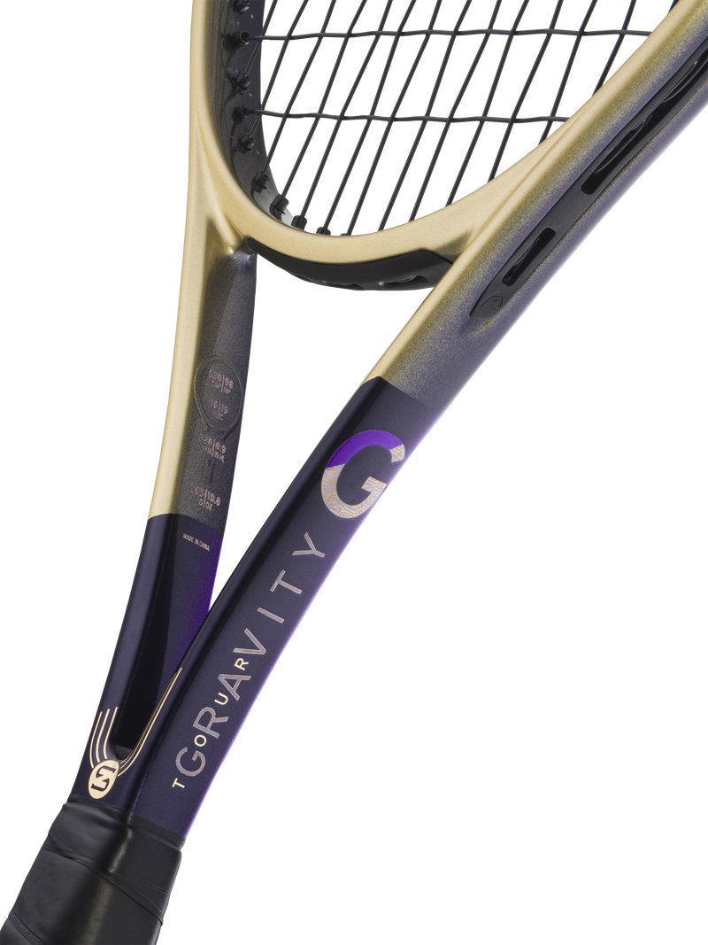 Close-up of a tennis racket showing the throat and part of the frame, with a black and purple body and a gold-colored throat section, set against a solid white background.